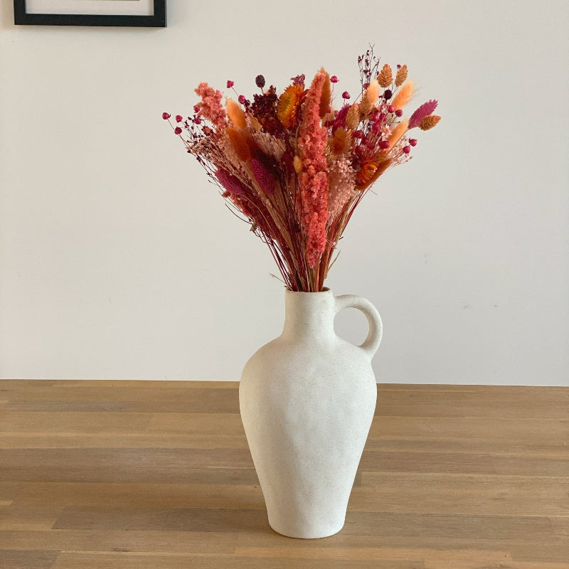 bouquet de fleurs sechees couleurs roses et orangees dans un vase