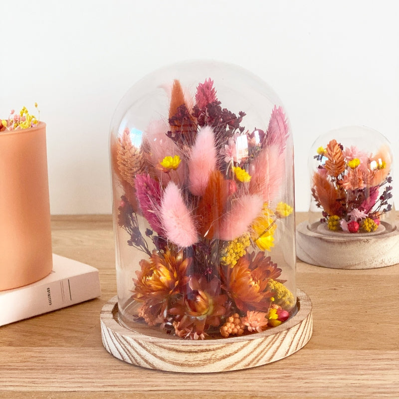composition florale fleurs sechees roses jaunes et ocres sous un globe en verre
