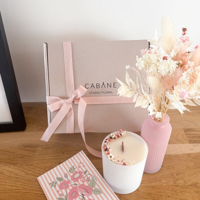 coffret cadeau avec bouquet de fleurs sechees dans les tons blancs et roses, bougie fleurie et vase rose