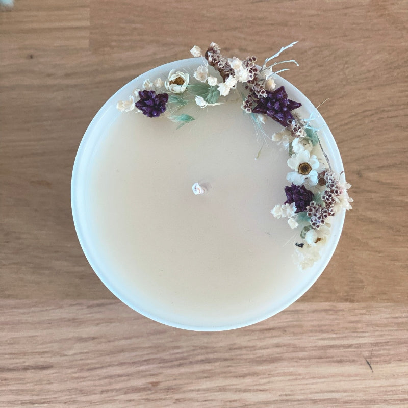 bougie fleurie decoree de petites fleurs sechees dans les tons blanc bleu polaire et violet