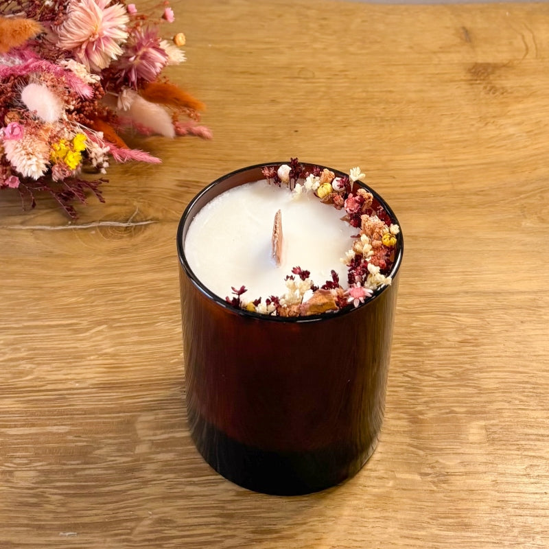 bougie capucine décorée de fleurs séchées dans les tons rose et terracotta et sa meche en bois