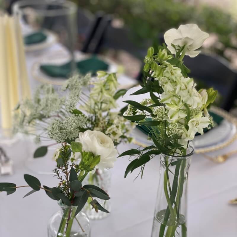 petits soliflores avec fleurs blanches et feuillage pour décorer les tables mariage elegant et champetre
