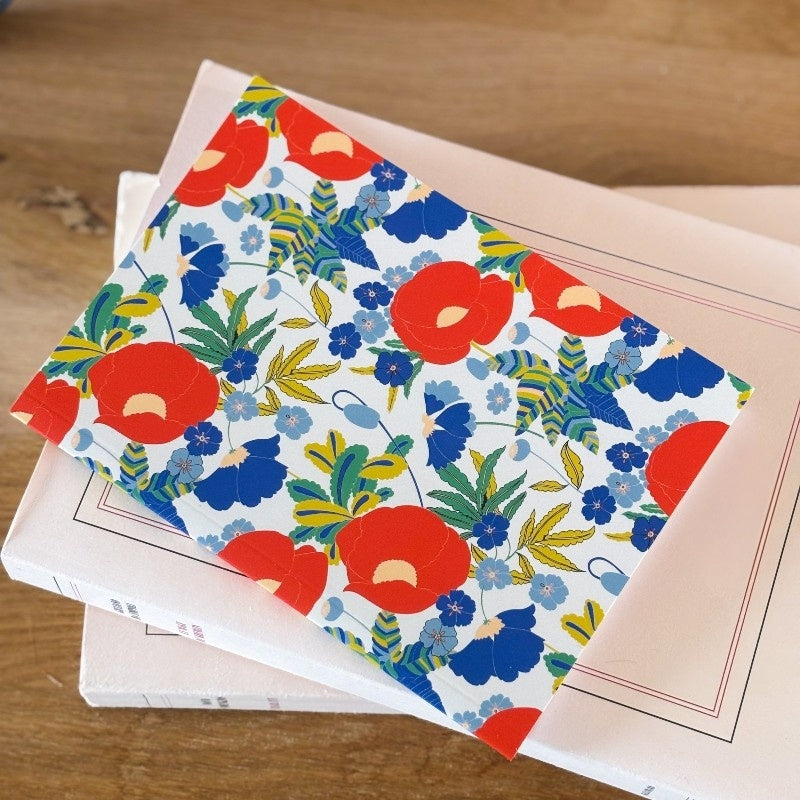 carnet de notes format A6 avec une illustration florale colorée dans les tons rouge, vert, bleu et blanc. 