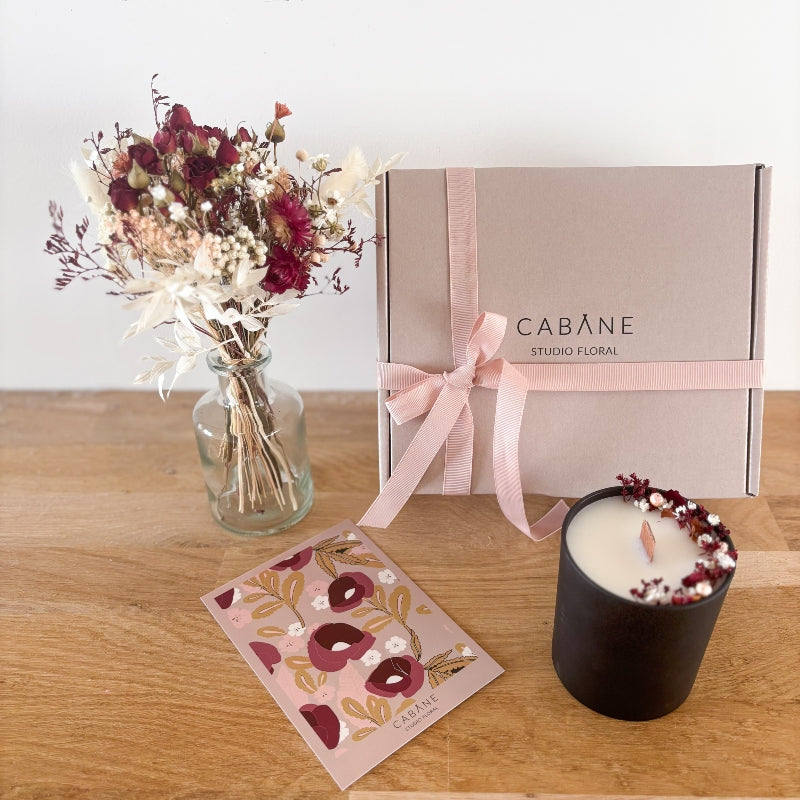 coffret cadeau scarlet composé d'un bouquet de petites roses rouges séchées et de fleurs séchées dans les tons rose poudré et blanc, d'une bougie fleurie et d'un vase