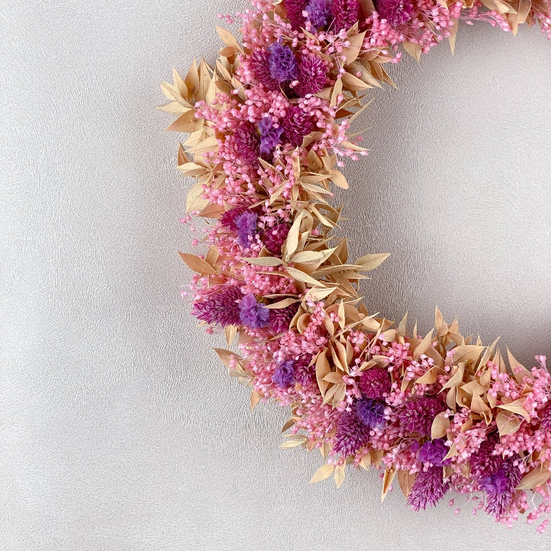 couronne de fleurs sechees dans les coloris rose violet peche decoration murale