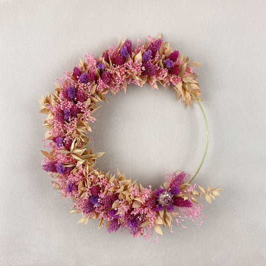 couronne de fleurs sechees capucine dans les coloris rose violet peche decoration murale
