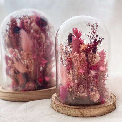 composition fleurs sechees dans les tons roses socle en bois et globe en verre