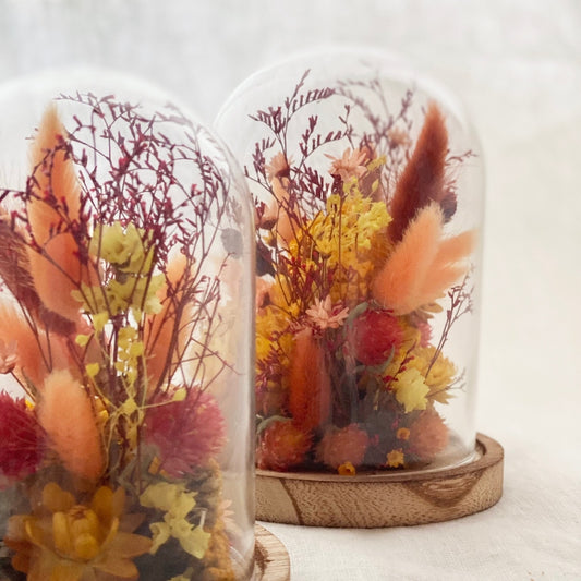 globe fleuri soleil fauve fleurs sechees tons ocre, miel et caramel sur un socle en bois avec un globe en verre